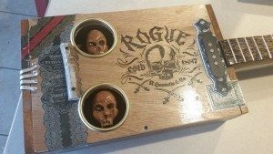 Spooky inset skull sound holes in a cigar box guitar by Jeff Cox.