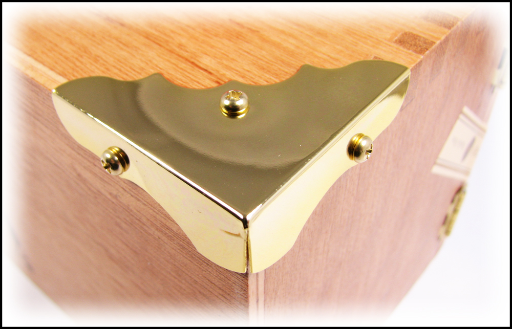 Shiny gold metal box corner mounted on a cigar box.